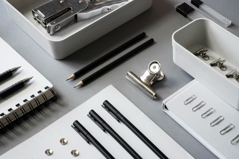 Open cupboard revealing various office essentials stored in compartments.